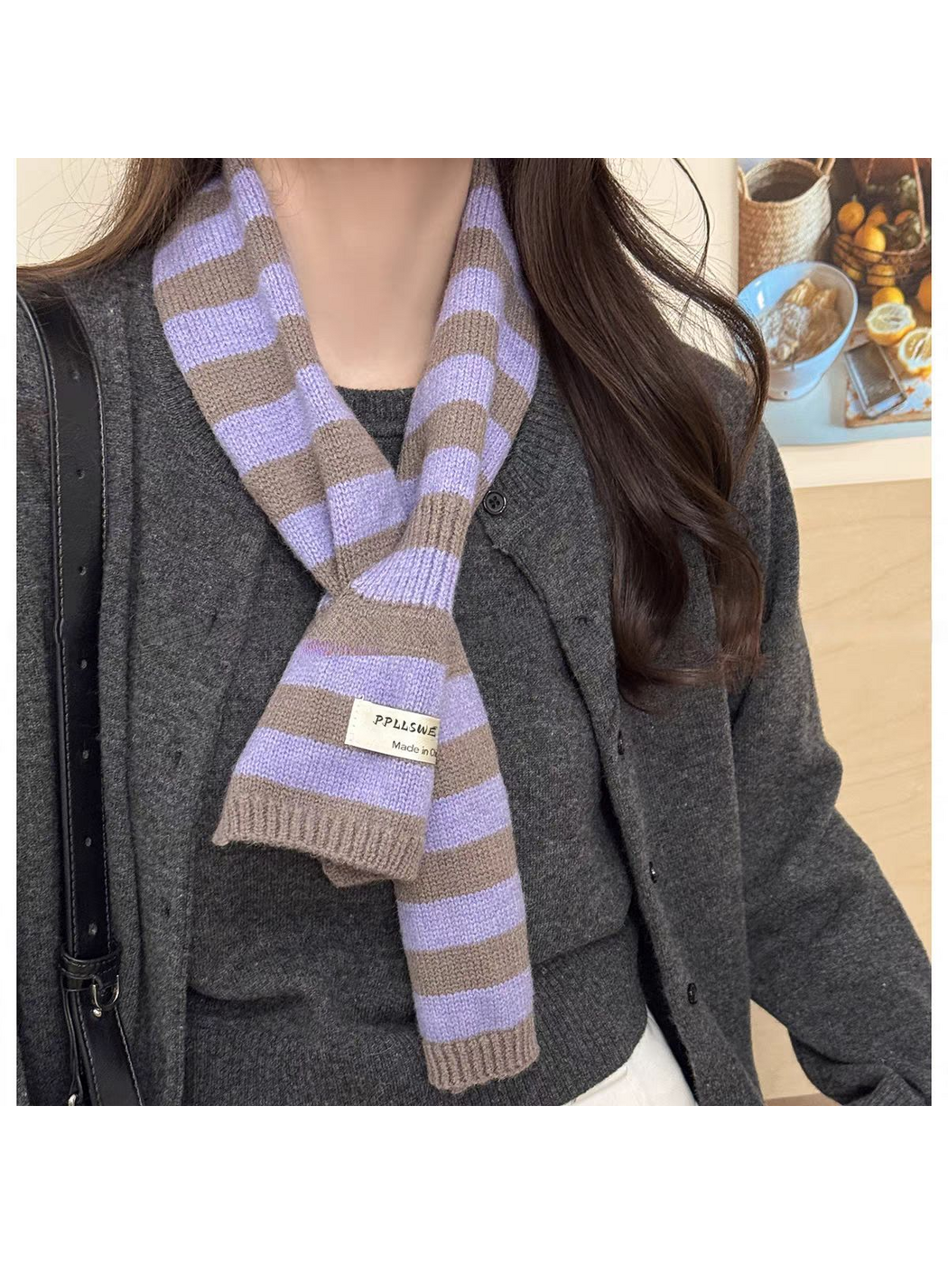 Purple striped knit scarf looped over a dark gray cardigan