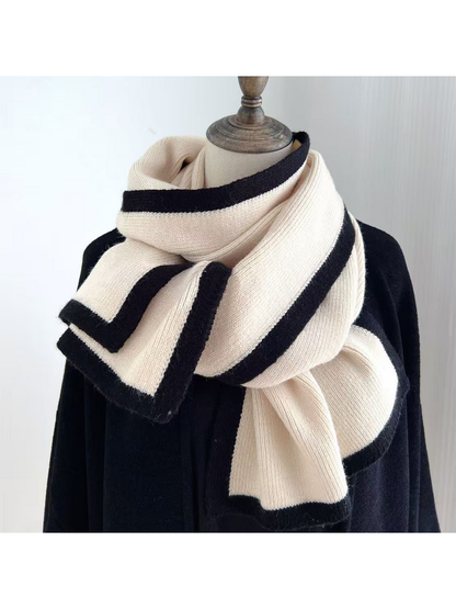 Cream knit scarf with black border stripes draped around a mannequin
