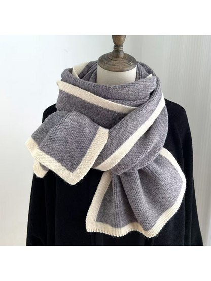 Gray knit scarf with cream border stripes draped around a mannequin