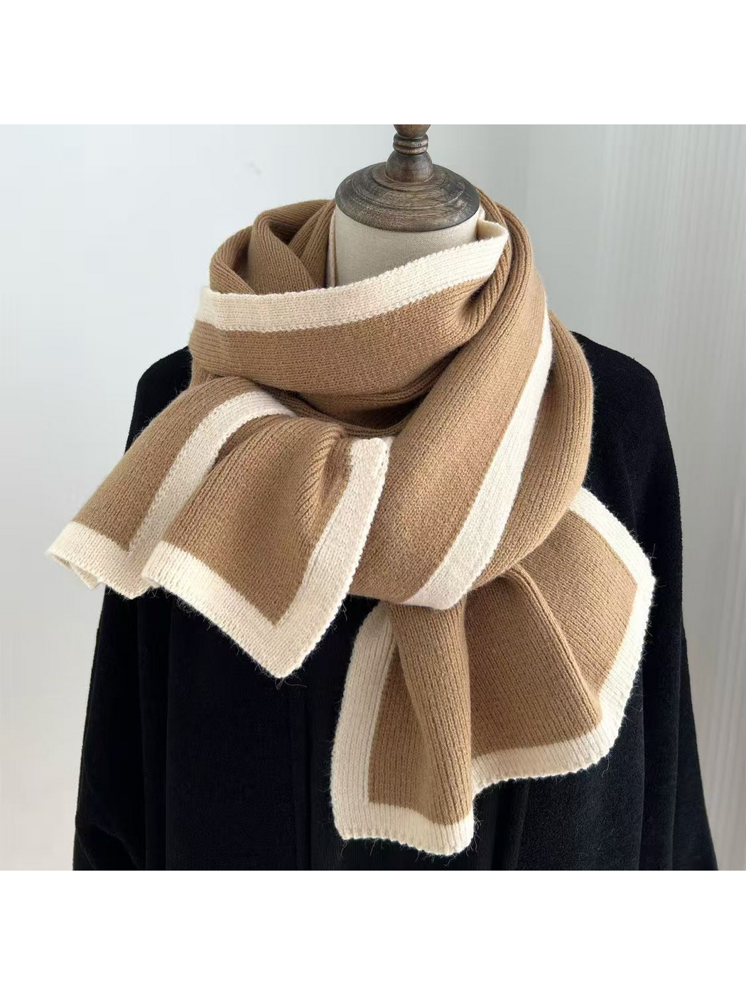 Camel knit scarf with cream border stripes draped around a mannequin