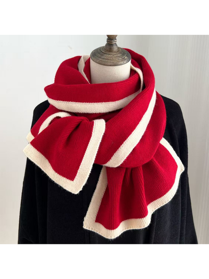 Red knit scarf with cream border stripes draped around a mannequin