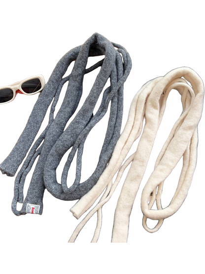 Gray and Ivory fuzzy narrow scarves arranged in loose loops over a black jacket