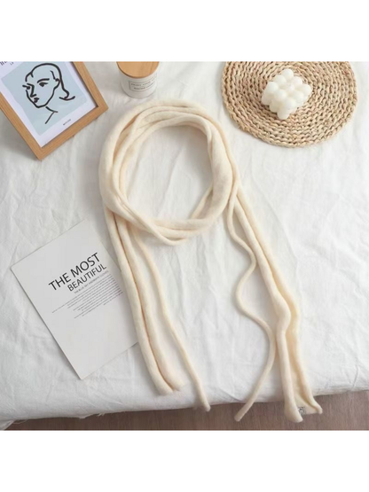 Ivory fuzzy narrow scarf arranged in a loose loop with long hanging ends