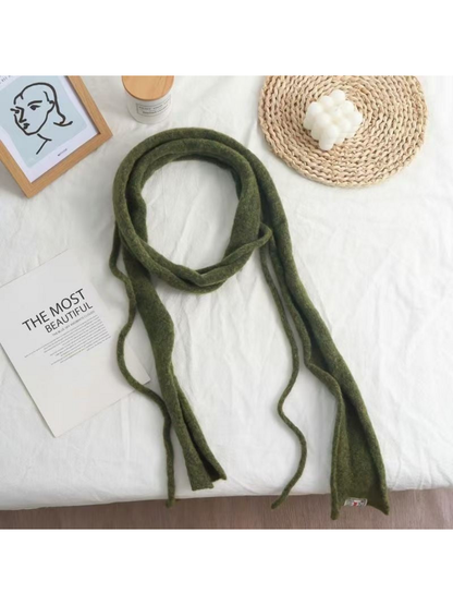 Green fuzzy narrow scarf arranged in a loose loop with long hanging ends