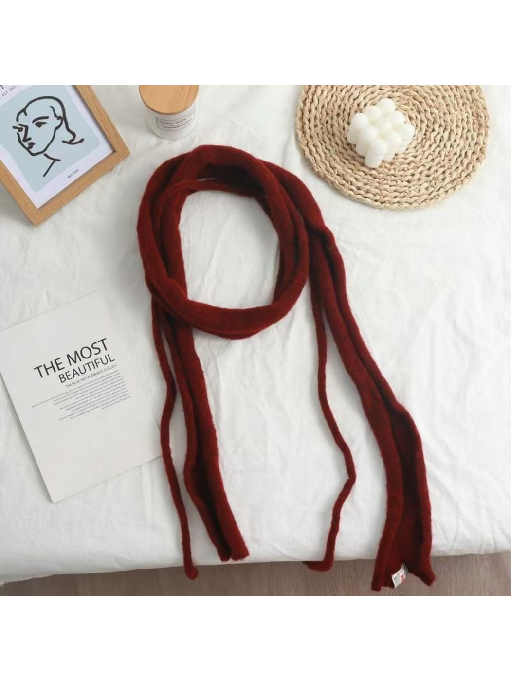 Burgundy fuzzy narrow scarf arranged in a loose loop with long hanging ends