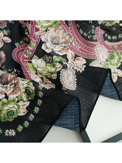 Close-up of Black scarf folds showing floral and paisley motifs and fine crosshatched texture