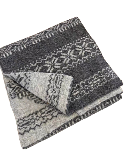 Gray snowflake-pattern scarf folded with a pale reverse corner, beside other folded scarves