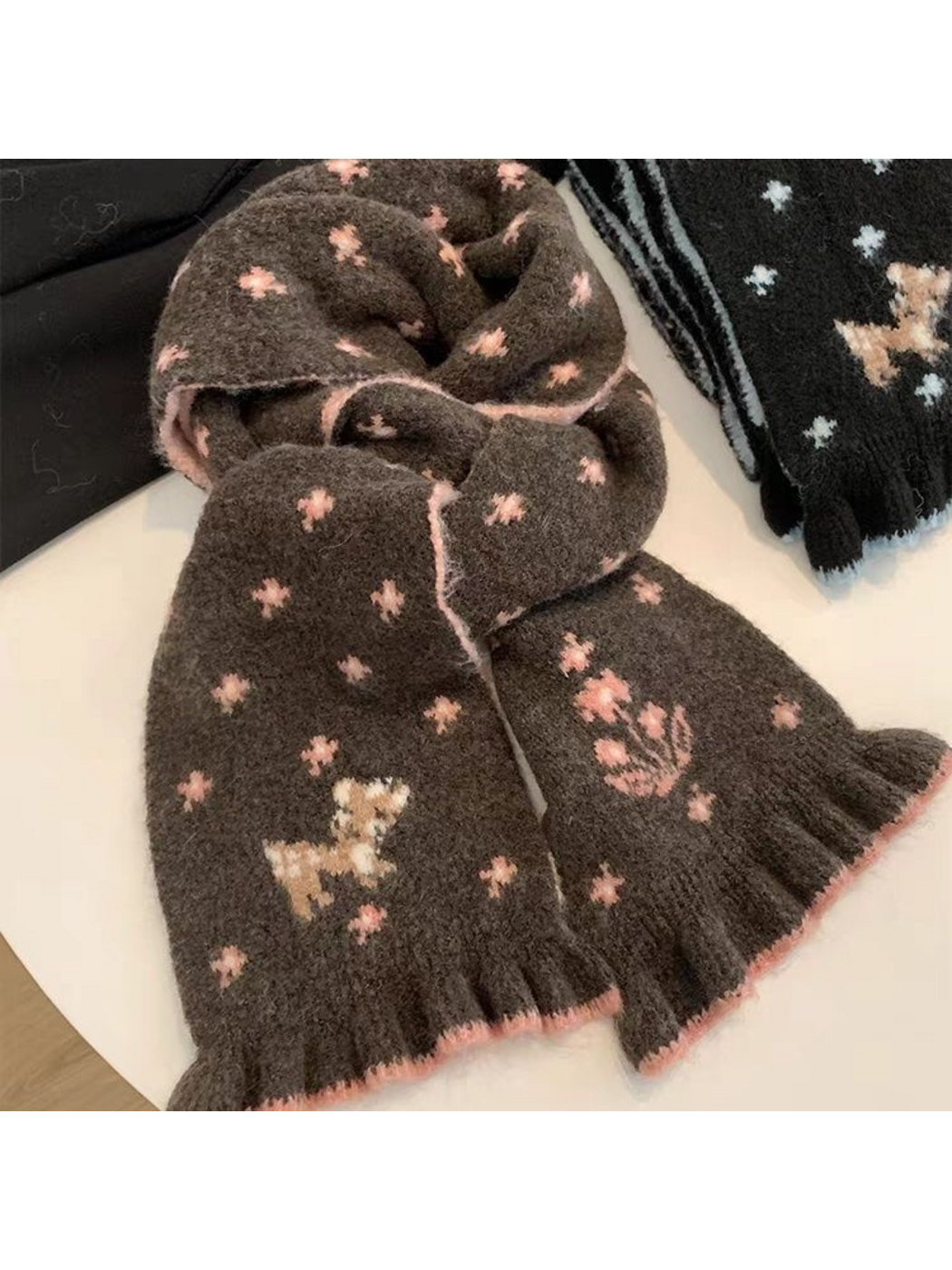 Brown scarf looped to show pink floral motifs, deer design and ruffled ends