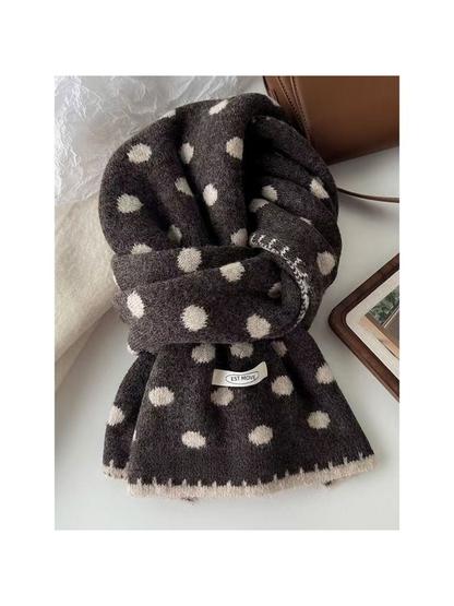 Gray polka dot scarf with light dots and edging, looped on a tabletop