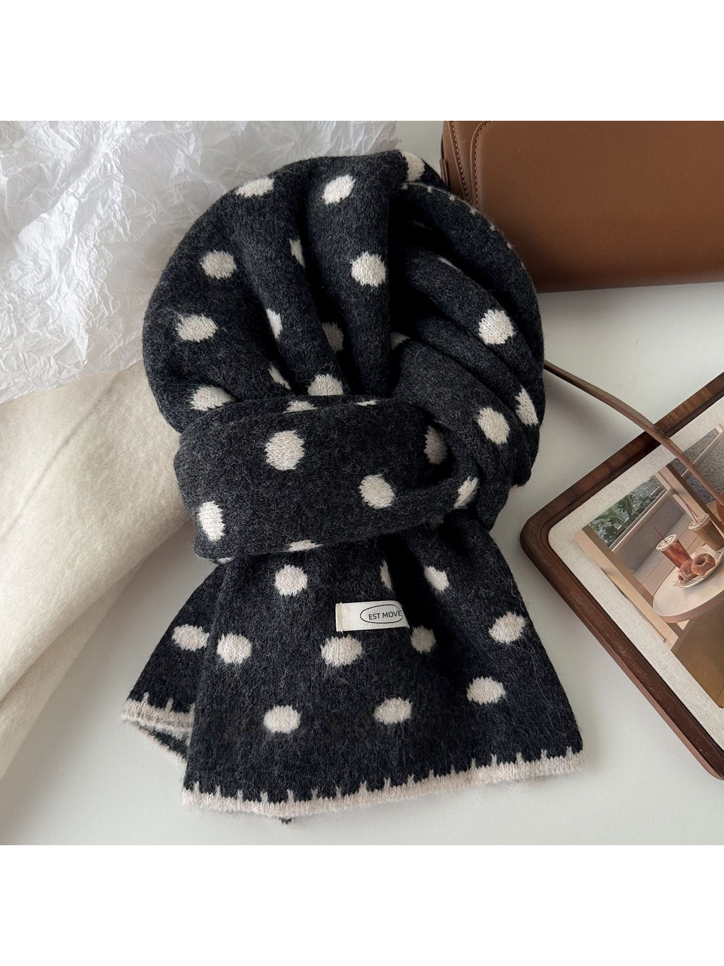 Dark Gray polka dot scarf with white dots and edging, looped on a tabletop