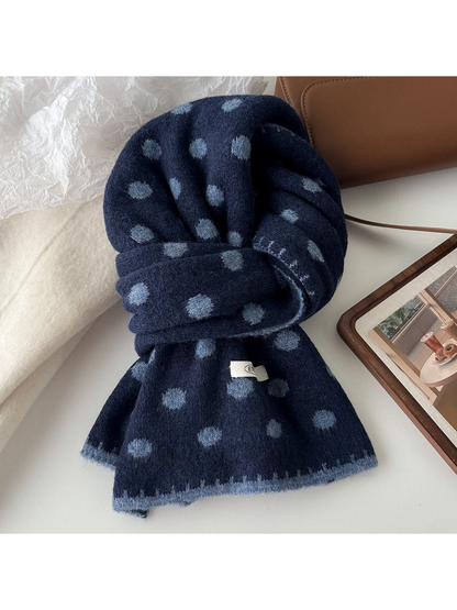 Navy polka dot scarf with blue-gray dots and edging, looped on a tabletop