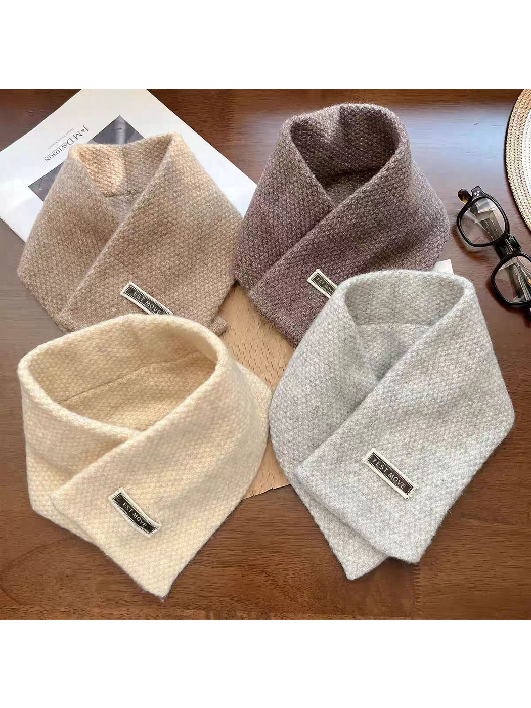 Four textured scarves displayed together on a wooden table