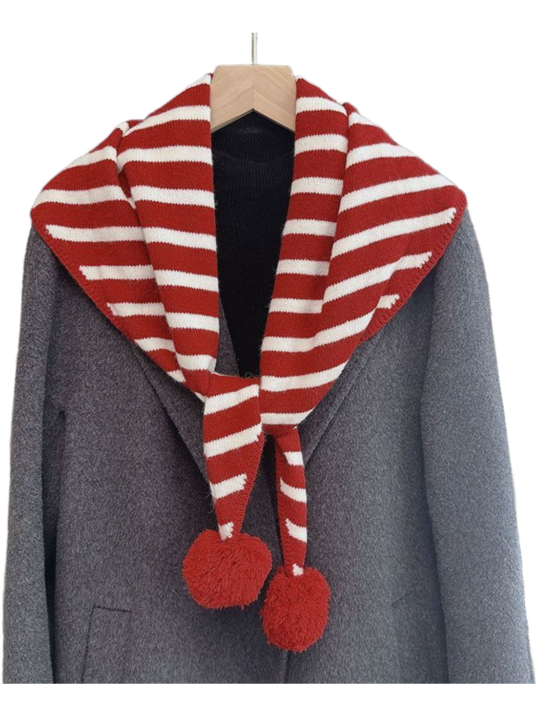 Red striped triangle scarf with pom-pom ends draped over a gray coat