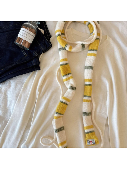 Yellow striped scarf over a cream top, close-up of the fuzzy surface and label