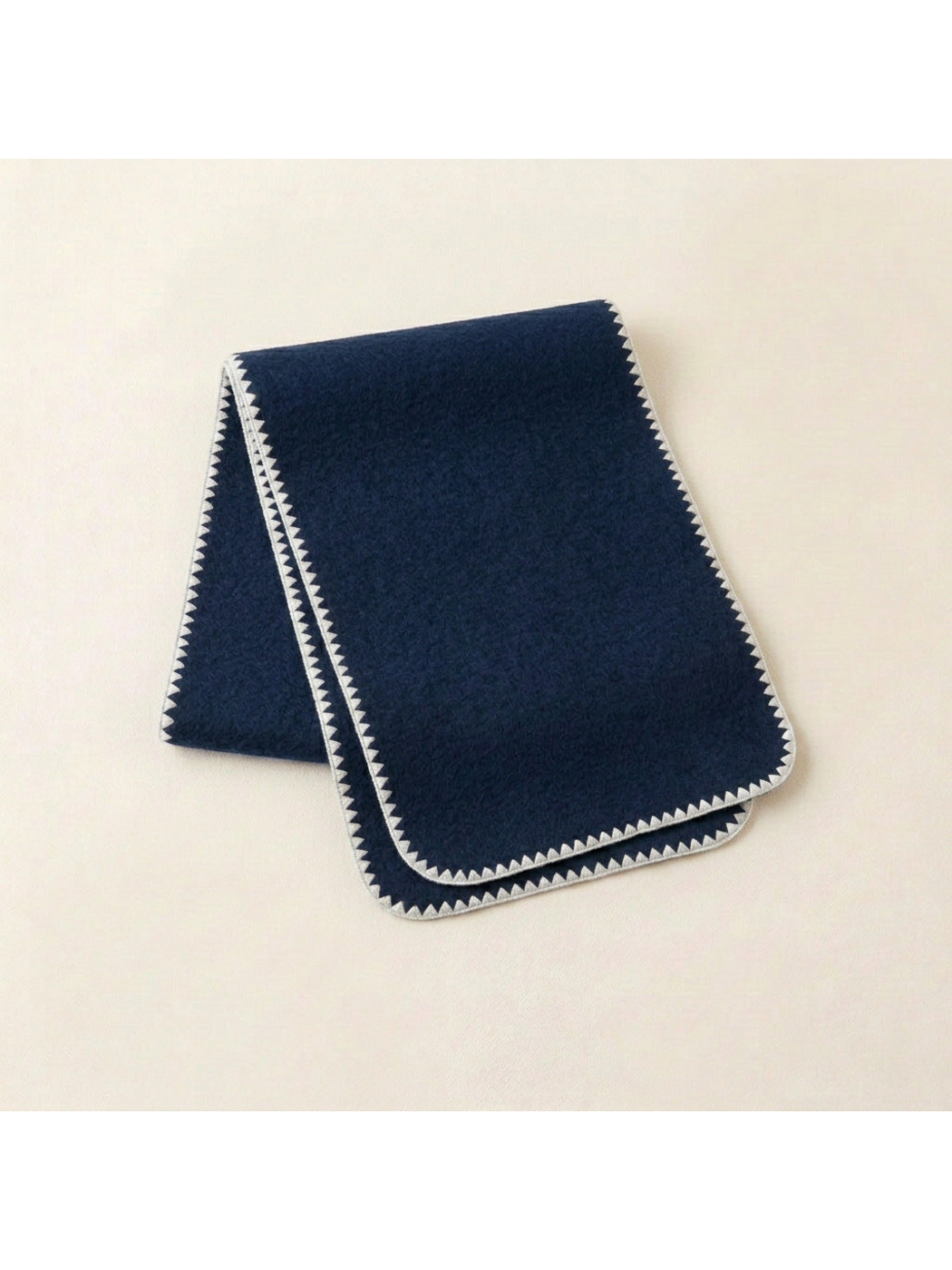 Navy scarf with ivory triangular edging and rounded corners, folded view