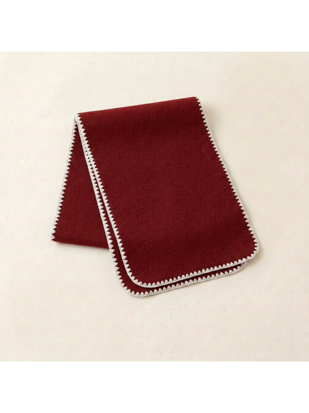 Burgundy scarf with ivory triangular edging and rounded corners, folded view