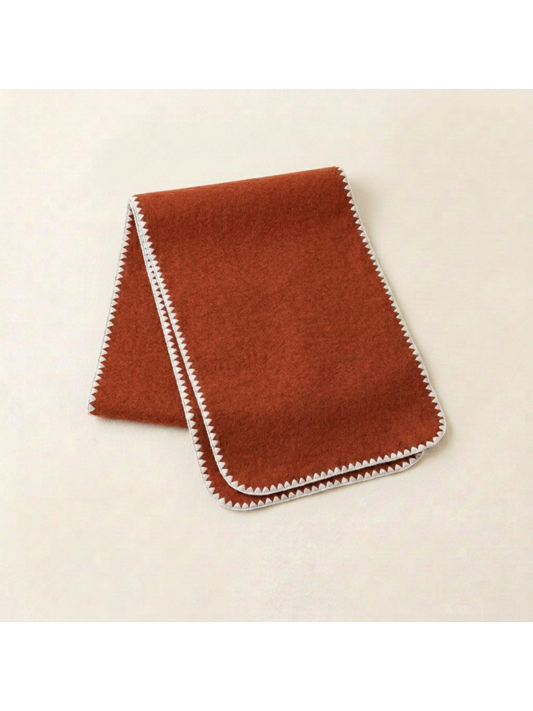 Orange scarf with ivory triangular edging and rounded corners, folded view