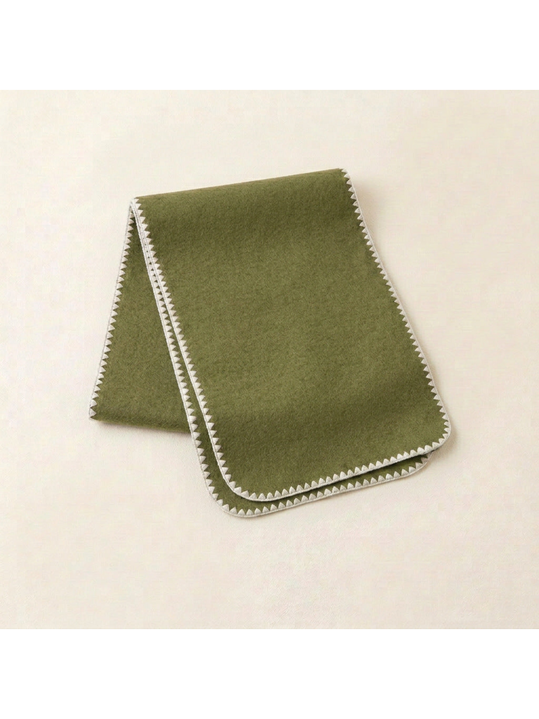Green scarf with ivory triangular edging and rounded corners, folded view