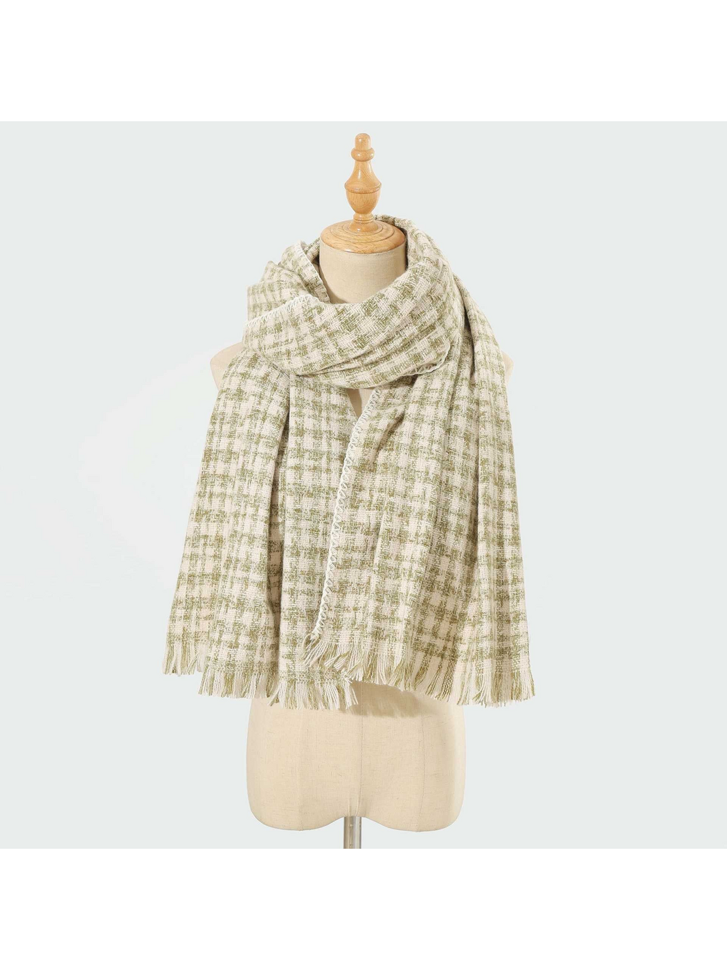 Green plaid scarf with fringed ends and stitched edging, looped on a mannequin