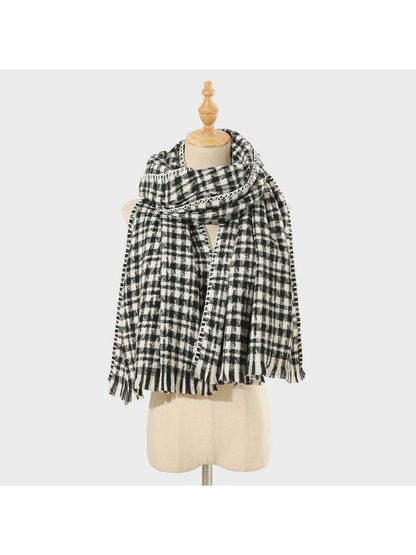 Black plaid scarf with white stitched edging and fringed ends, looped on a mannequin