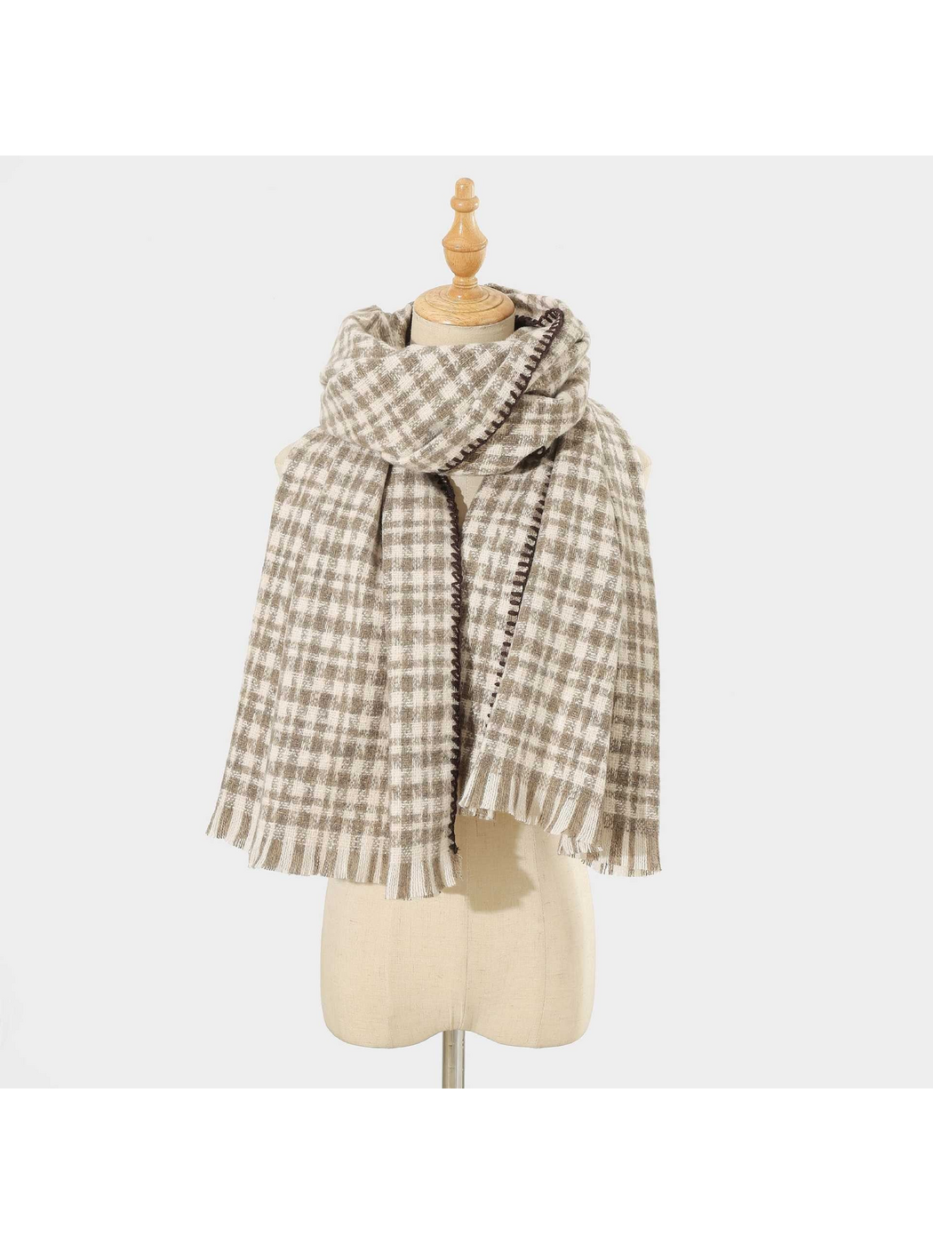 Gray plaid scarf with dark stitched edging and fringed ends, looped on a mannequin