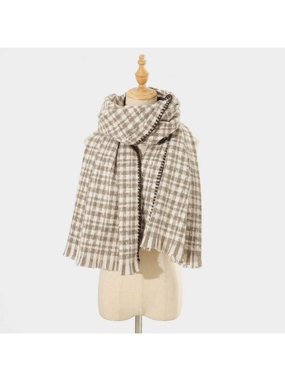 Gray plaid scarf with dark stitched edging and fringed ends, looped on a mannequin