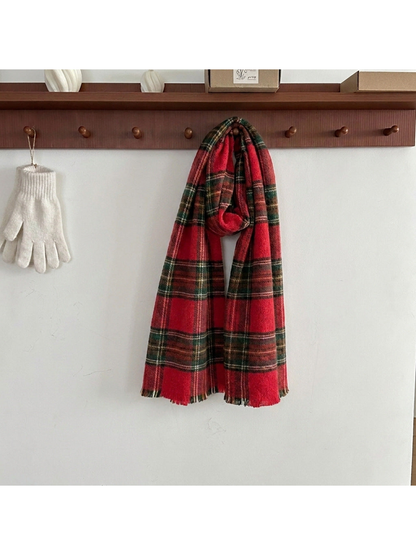 Red tartan plaid scarf looped over a wooden peg, showing short fringed ends