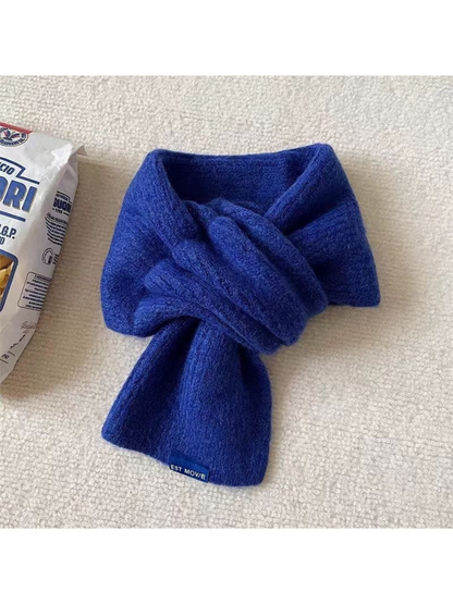 Blue scarf in a crossover arrangement with a blue end label
