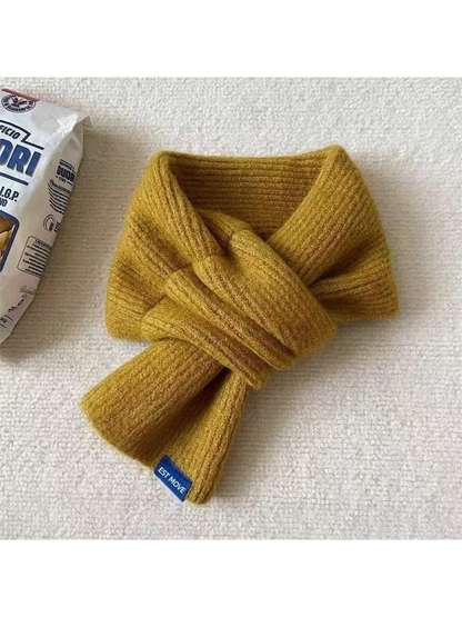 Yellow ribbed scarf in a crossover arrangement with a blue end label