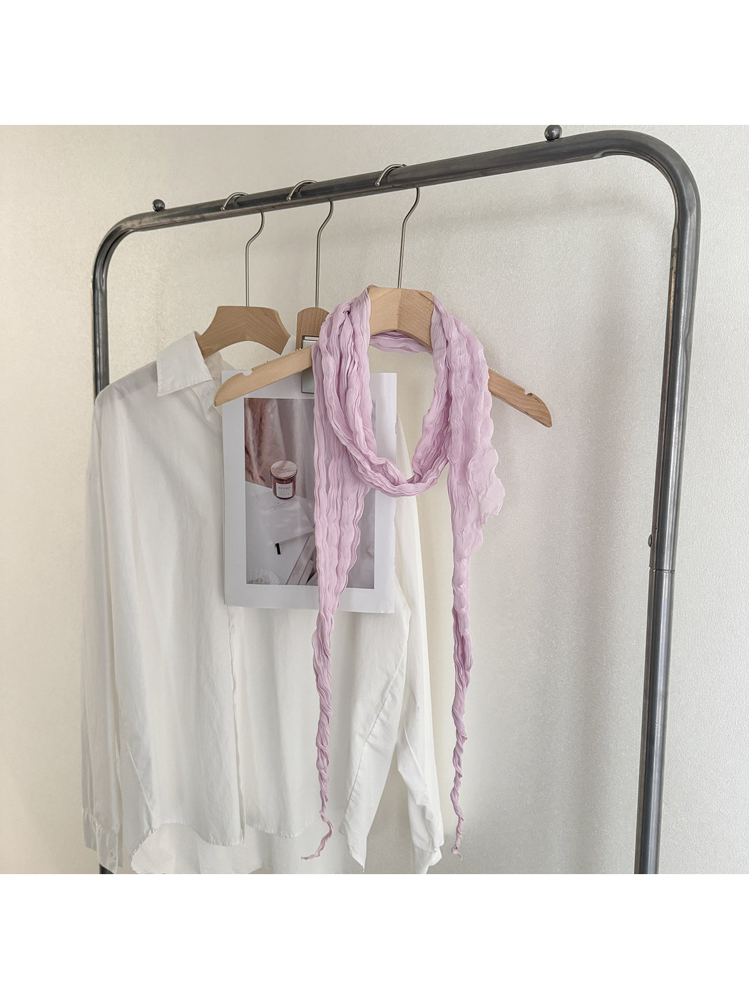Purple crinkled scarf looped on a wooden hanger with long tapered ends