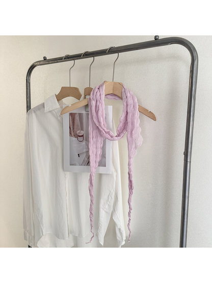 Purple crinkled scarf looped on a wooden hanger with long tapered ends