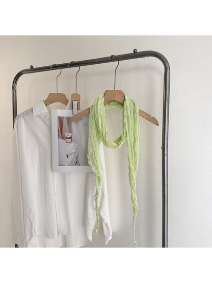 Mint crinkled scarf looped on a wooden hanger with long tapered ends
