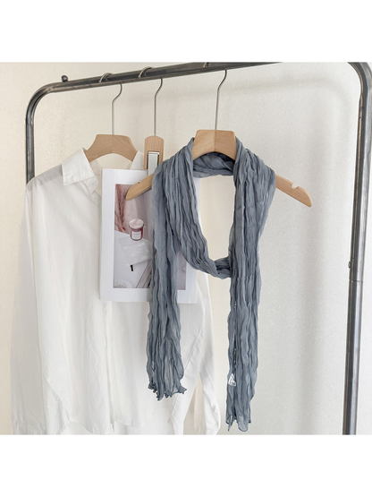 Blue crinkled scarf looped over a wooden hanger