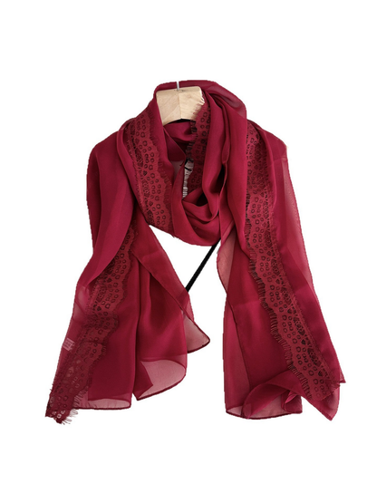 Burgundy scarf draped in a loop with lace borders and eyelash fringe