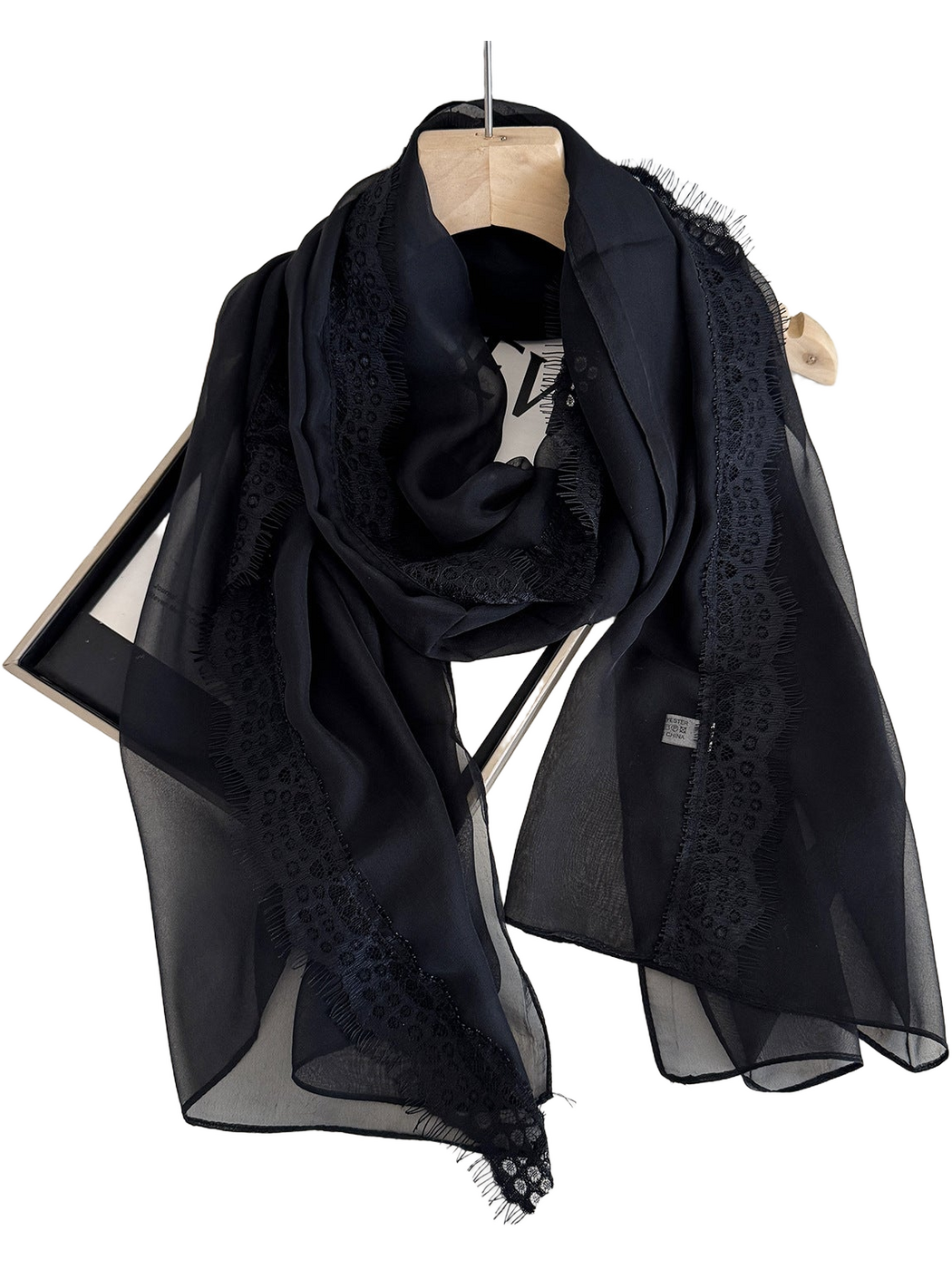 Black scarf draped in a loop with sheer panels and lace borders
