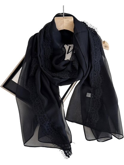 Black scarf draped in a loop with sheer panels and lace borders