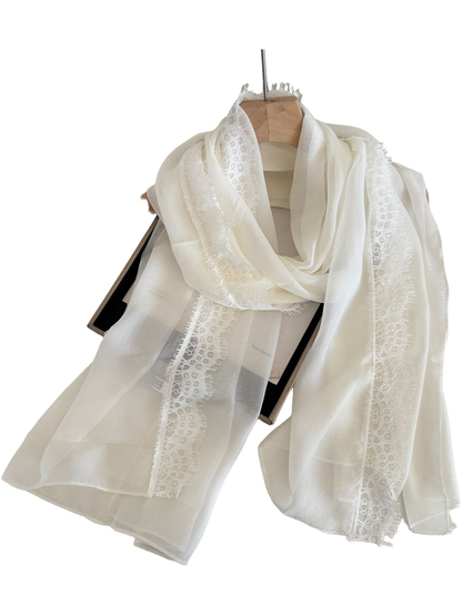 White scarf draped in a loop with sheer panels and lace borders