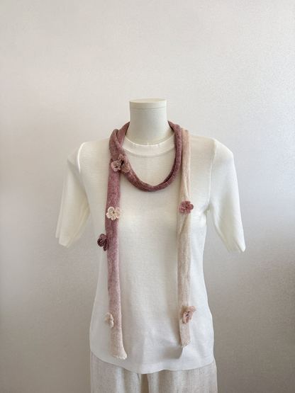 Brown gradient knit scarf with raised flower and butterfly embellishments draped on a mannequin