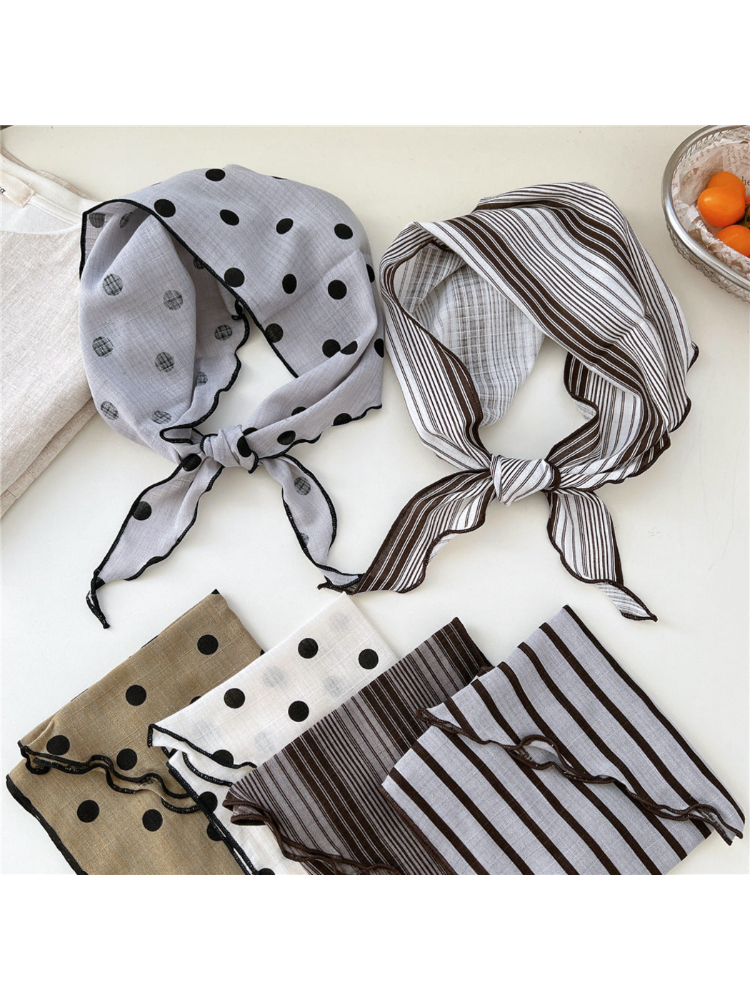 Polka dot and striped scarves shown tied and folded in several colors