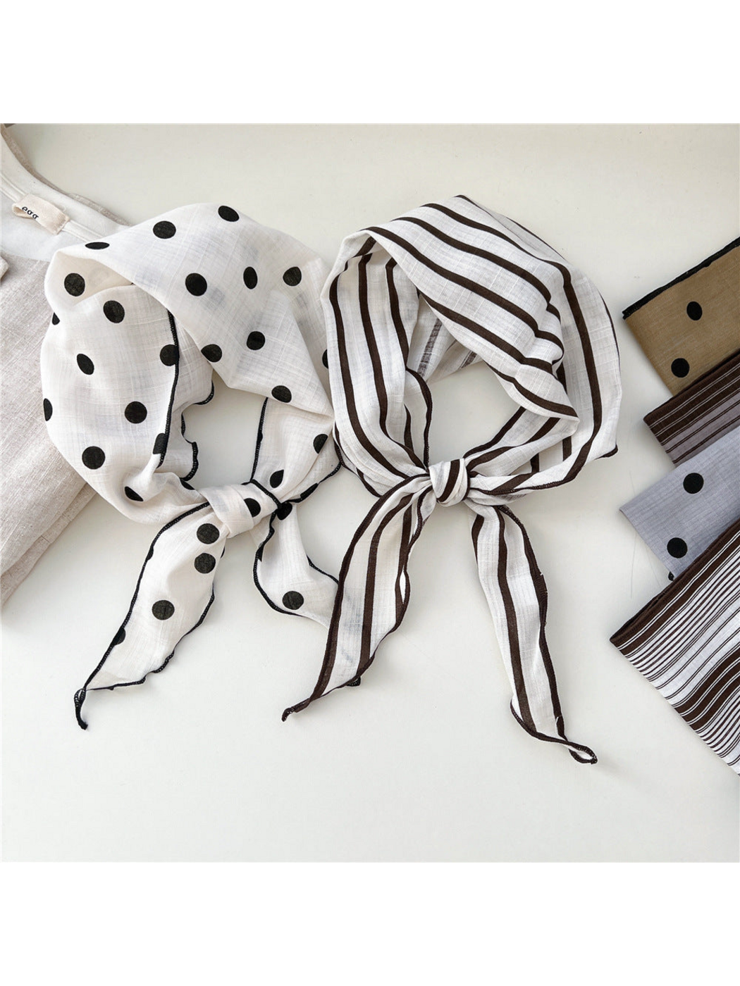 Ivory polka dot and single striped scarves tied side by side