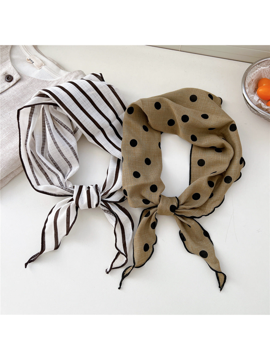 Ivory striped and khaki polka dot scarves tied side by side