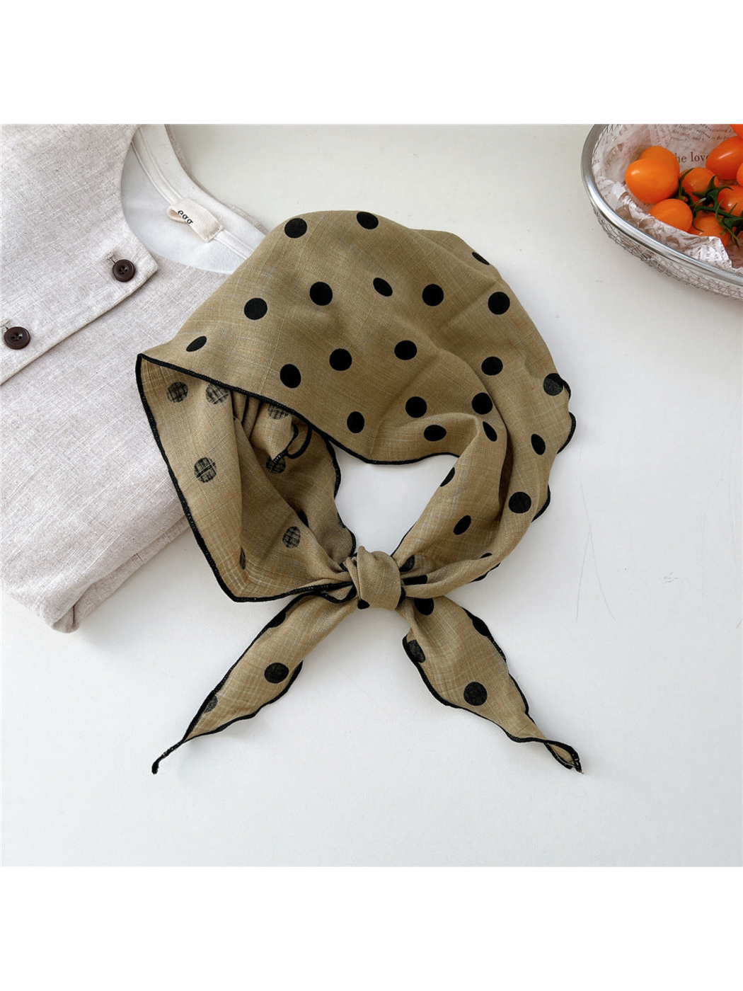 Khaki Dots triangle scarf tied in a loop with black stitched edges
