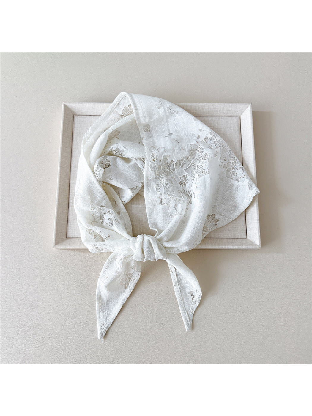 White floral lace scarf tied in a loop over a neutral tray