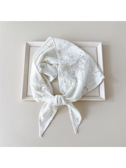 White floral lace scarf tied in a loop over a neutral tray