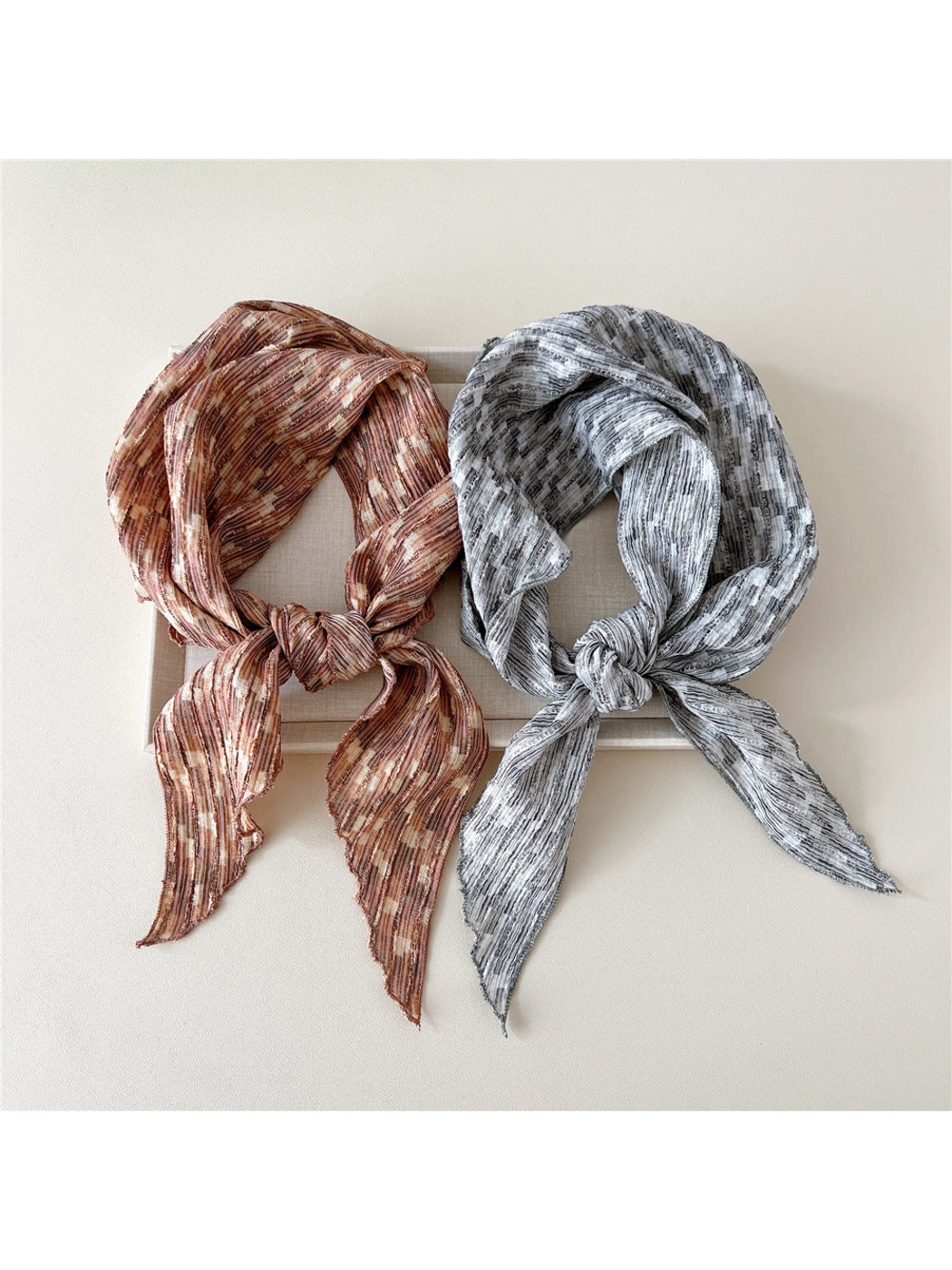 Brown and Gray striped triangle scarves looped side by side with knots and pointed ends