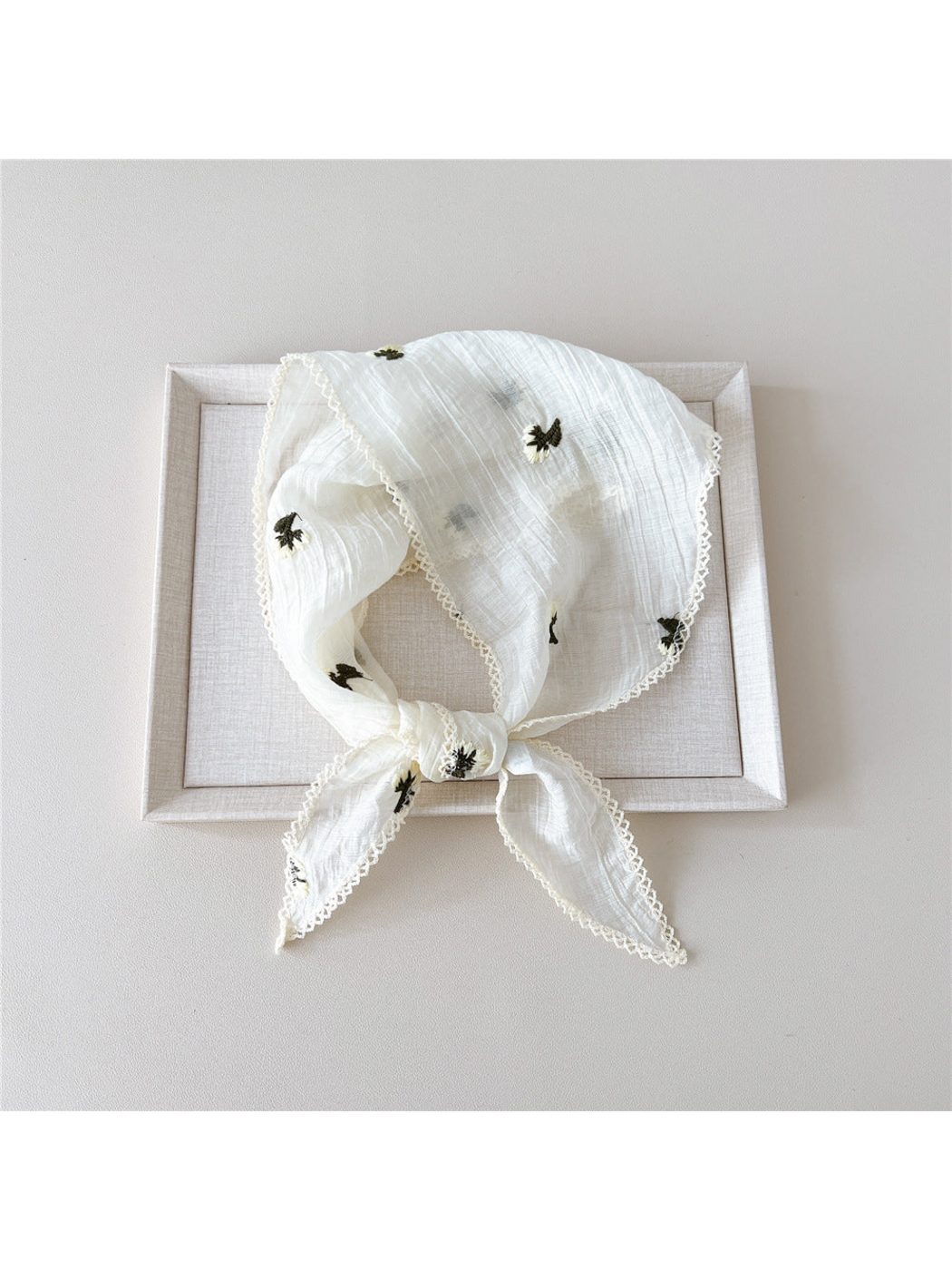 Cream floral scarf in a knotted loop with white openwork edge trim