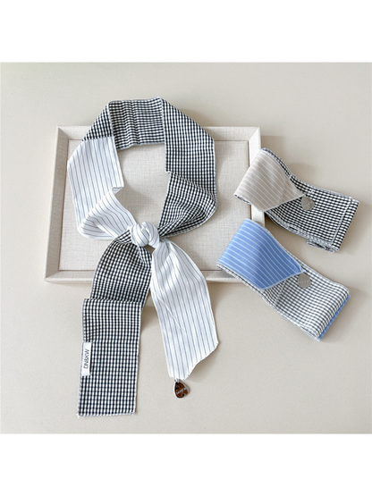 White scarf in a knotted loop beside folded Beige and Blue scarves