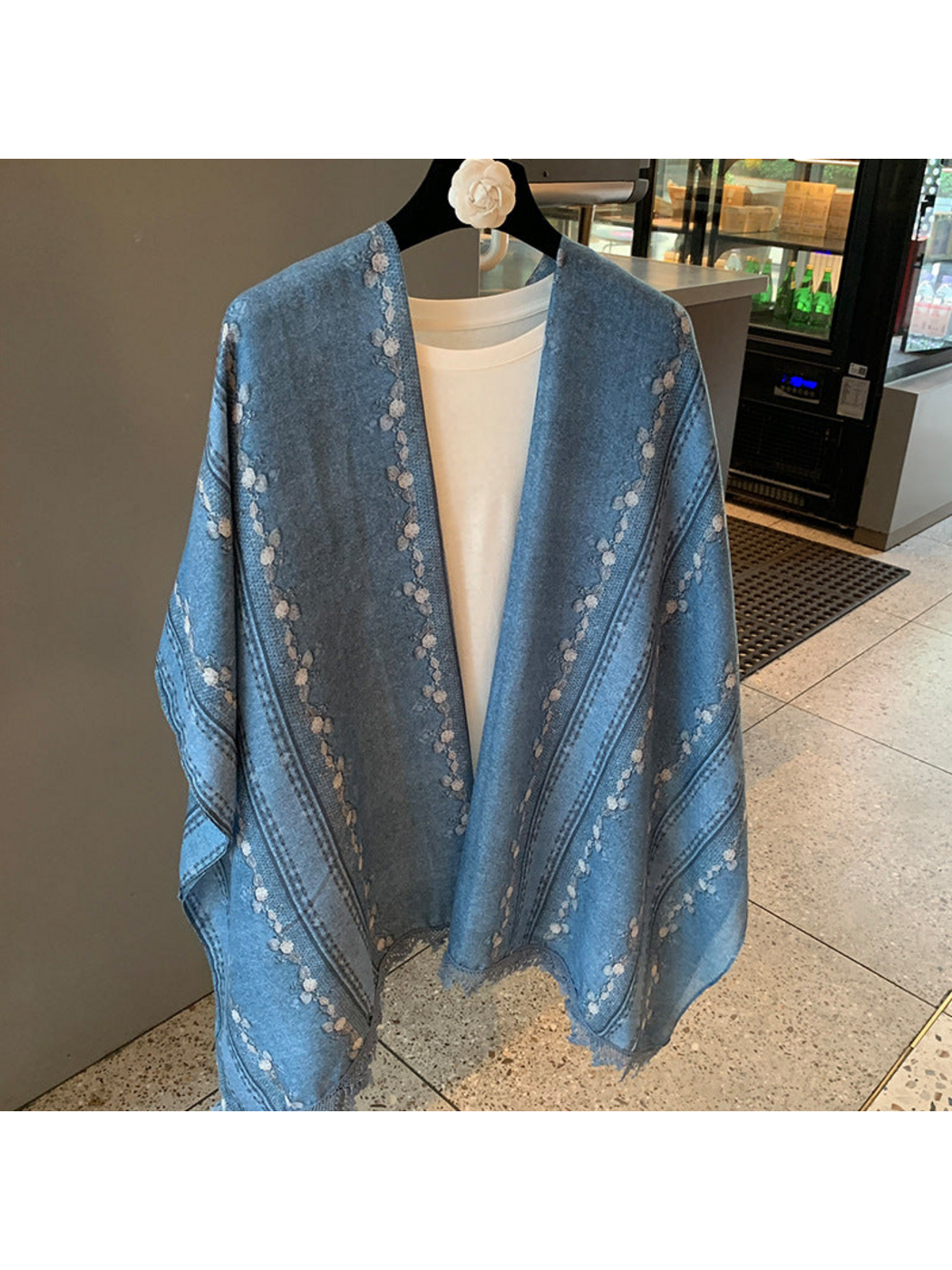 Blue floral and striped scarf hanging open, showing its borders and fringed edges