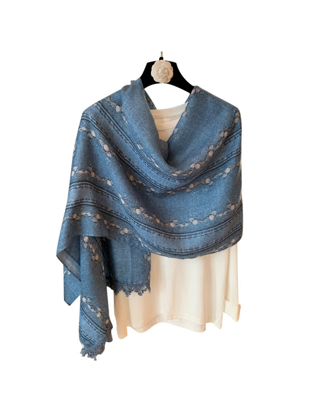 Blue floral and striped scarf draped asymmetrically over a white top on a white background