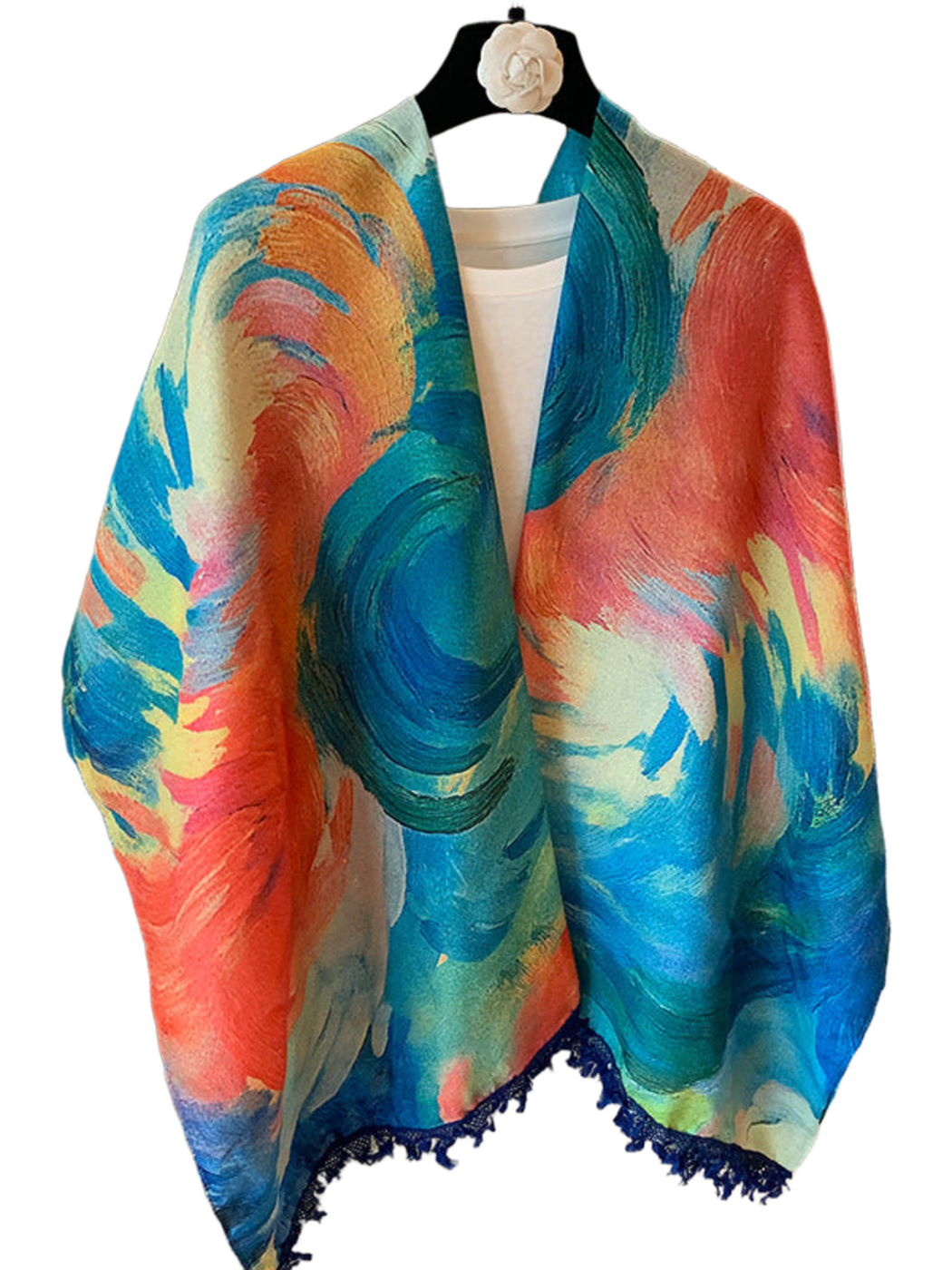 Blue scarf with multicolored painterly swirls and dark blue fringe, hanging in an open drape